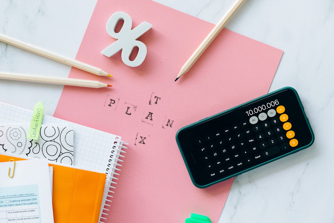 our-experience Flat lay showing tax planning tools including a calculator, pencils, and stationery items.